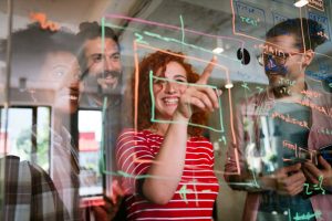Team collaborating on ideas at a glass wall